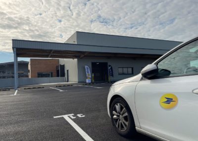 Voiture La Poste devant bâtiment